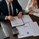 Auditor revisando un dictamen de estados financieros junto con información contable de una empresa.